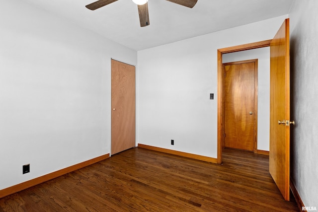 empty room with baseboards, ceiling fan, and dark wood-style flooring