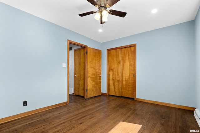 unfurnished bedroom featuring a ceiling fan, wood finished floors, a closet, a baseboard radiator, and baseboards