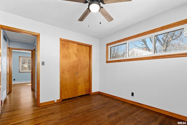 unfurnished bedroom with a closet, multiple windows, and wood finished floors