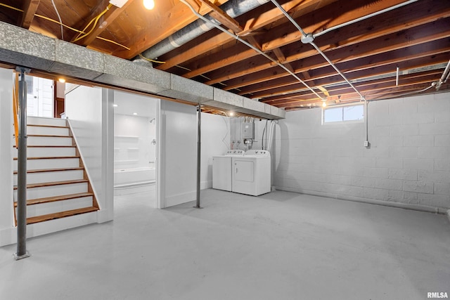 basement with electric panel, stairway, and washing machine and dryer