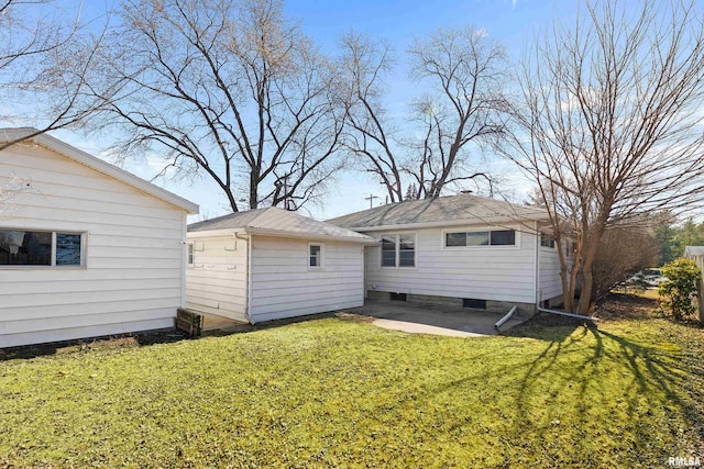 back of house with an outbuilding, a yard, and a patio area