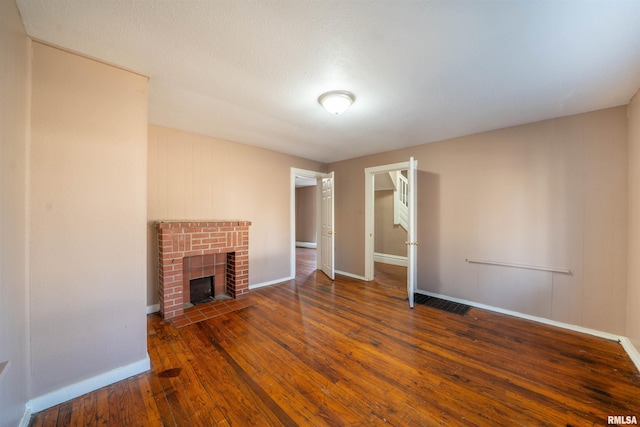 unfurnished living room featuring hardwood / wood-style floors, a fireplace, and baseboards