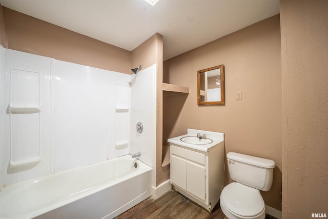 bathroom with vanity, wood finished floors, baseboards, shower / bathing tub combination, and toilet