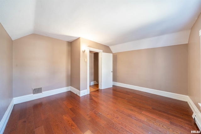 additional living space featuring vaulted ceiling, visible vents, and hardwood / wood-style floors