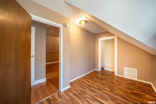 bonus room with wood finished floors, visible vents, baseboards, vaulted ceiling, and a textured ceiling