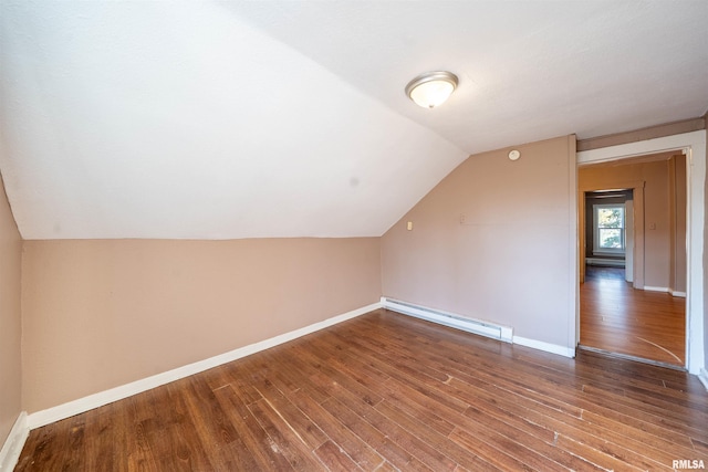 additional living space featuring vaulted ceiling, wood finished floors, baseboards, and baseboard heating