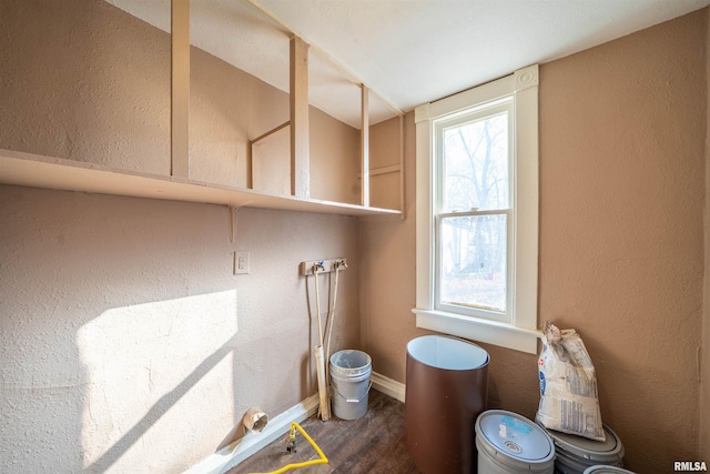 bathroom with a textured wall, baseboards, and wood finished floors