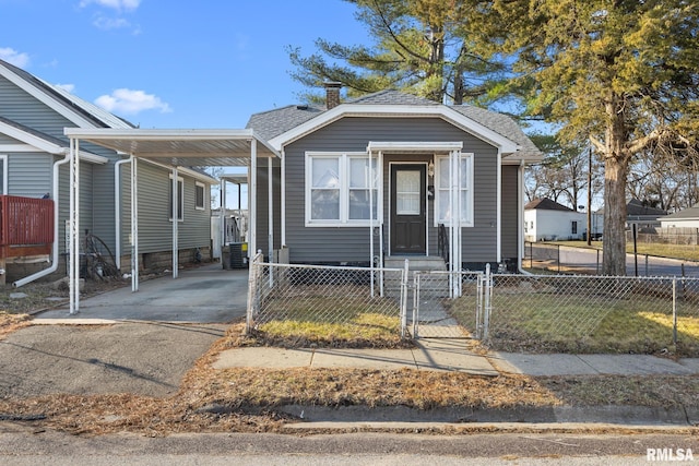 view of front of house featuring a fenced front yard, a carport, and entry steps