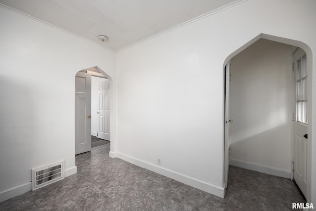 spare room with arched walkways, visible vents, crown molding, and baseboards