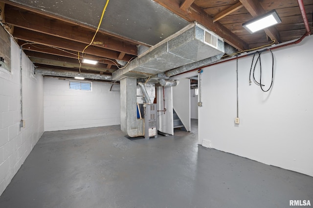 below grade area featuring heating unit and stairs