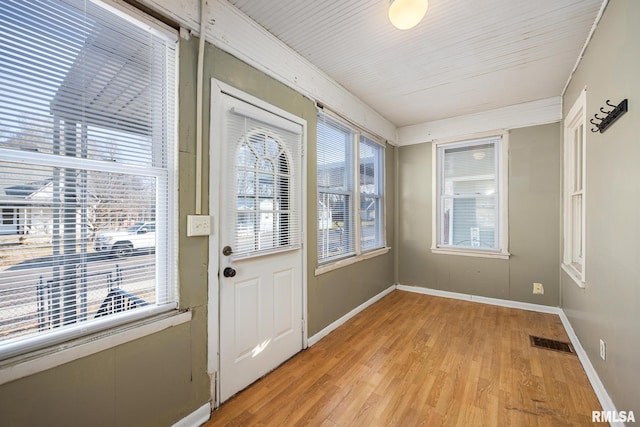 doorway with light wood-style flooring, baseboards, and visible vents