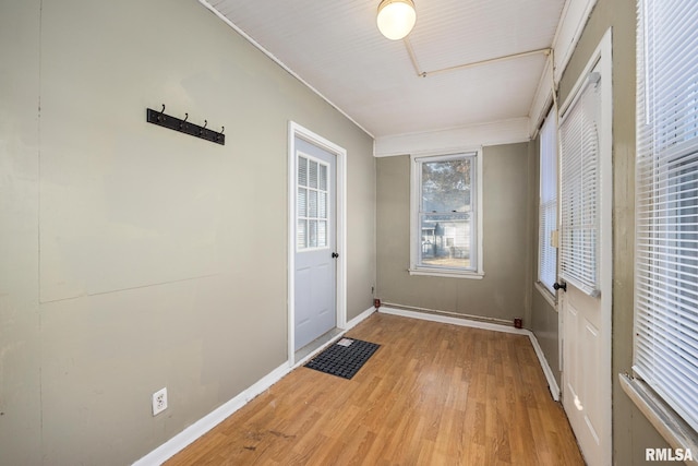 doorway with baseboards and light wood-style floors