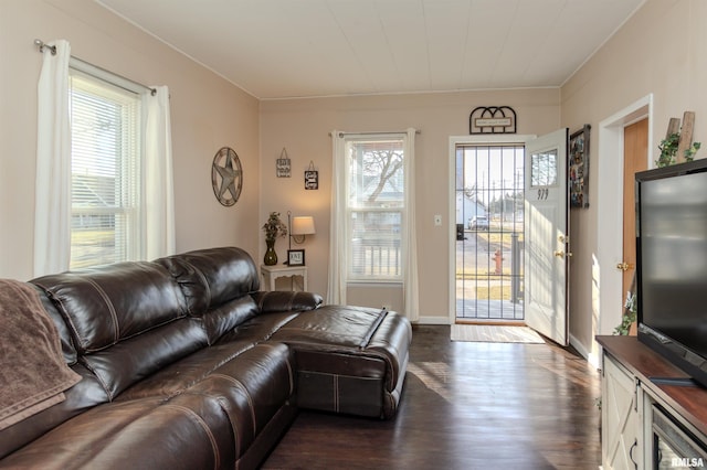 living area featuring dark wood-type flooring, crown molding, and baseboards