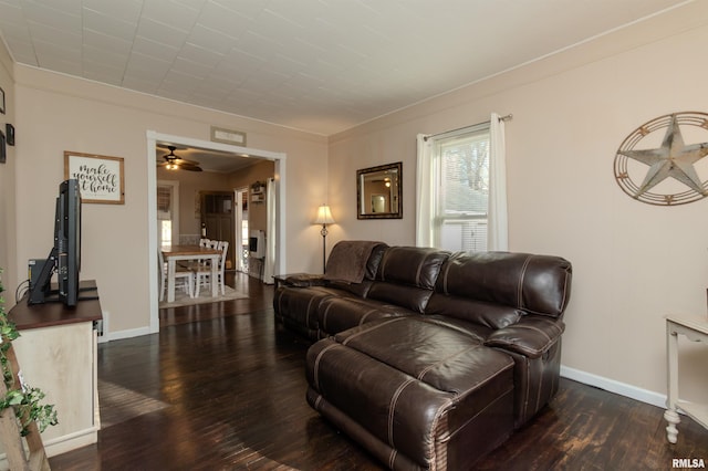 living room featuring baseboards, ceiling fan, and wood finished floors