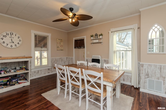 dining space with visible vents, ceiling fan, ornamental molding, wainscoting, and wood finished floors