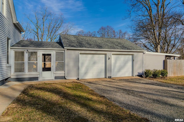 garage with fence and driveway