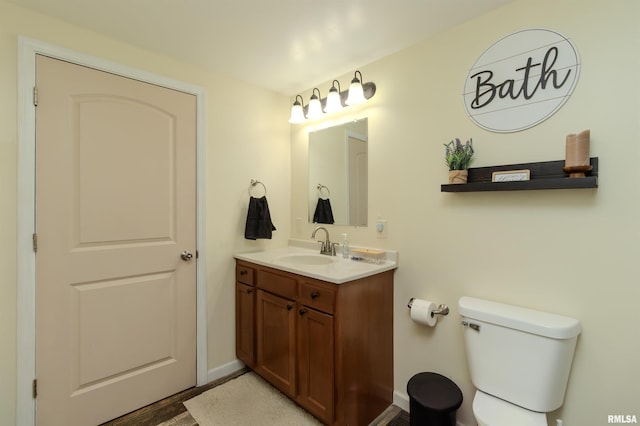 bathroom with vanity, toilet, and baseboards