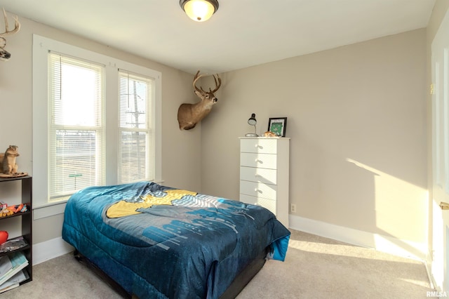 bedroom with baseboards and carpet