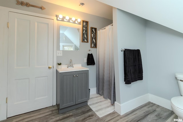 bathroom featuring toilet, curtained shower, wood finished floors, baseboards, and vanity