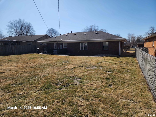 rear view of house featuring a lawn and fence