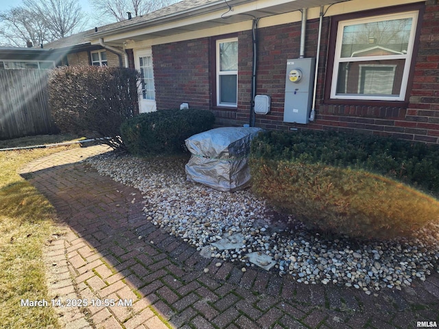 property entrance featuring brick siding and fence