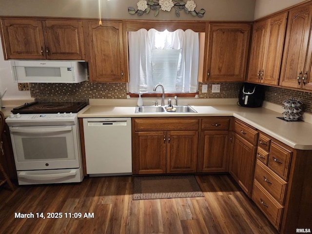 kitchen featuring a sink, white appliances, dark wood-type flooring, and light countertops