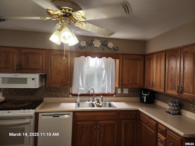 kitchen with a sink, white appliances, a ceiling fan, and light countertops