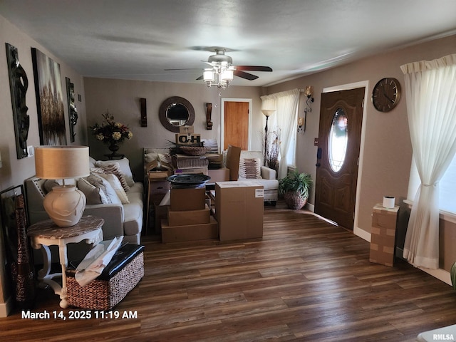 living room with dark wood finished floors, baseboards, and ceiling fan