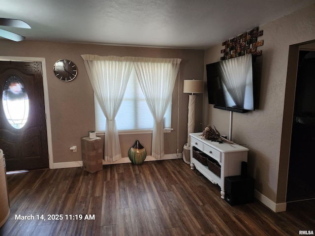 foyer entrance with baseboards, wood finished floors, a ceiling fan, and a textured wall