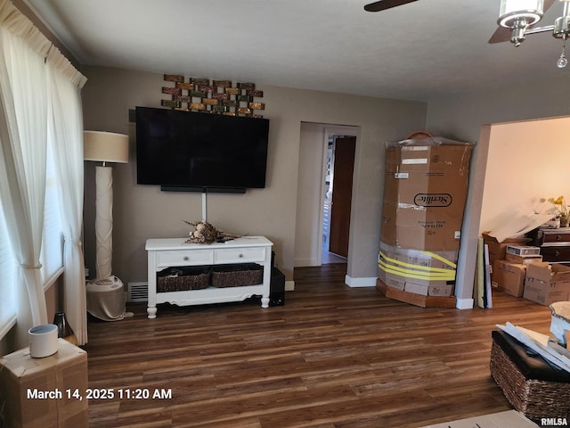 living area with a ceiling fan, wood finished floors, and baseboards