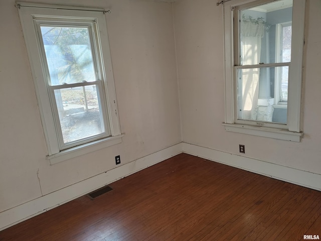 spare room featuring visible vents and dark wood-style flooring