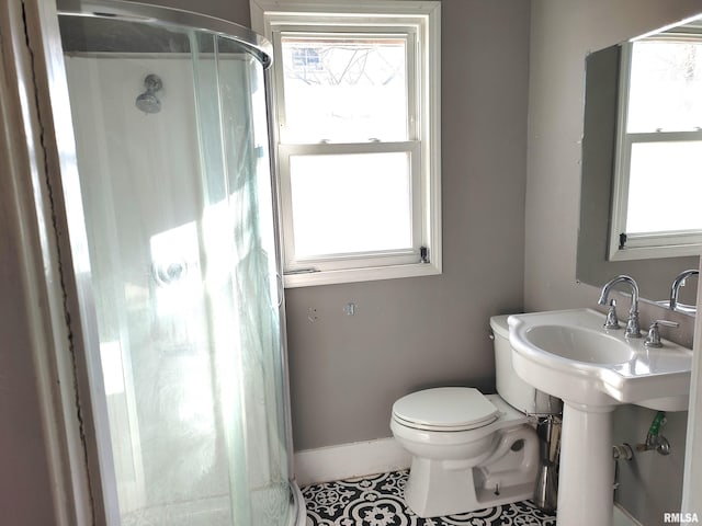 full bath featuring baseboards, toilet, a stall shower, and tile patterned flooring