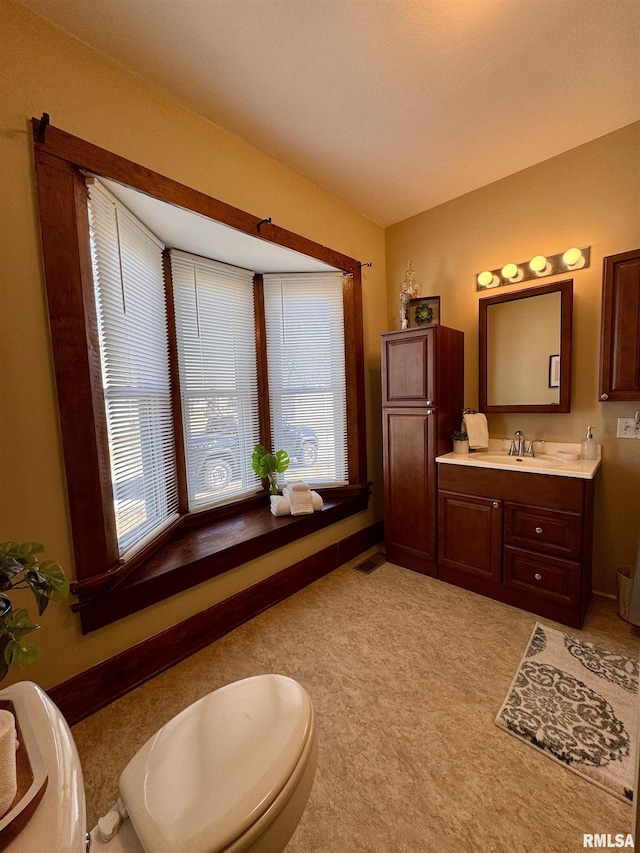 bathroom featuring baseboards, plenty of natural light, and vanity