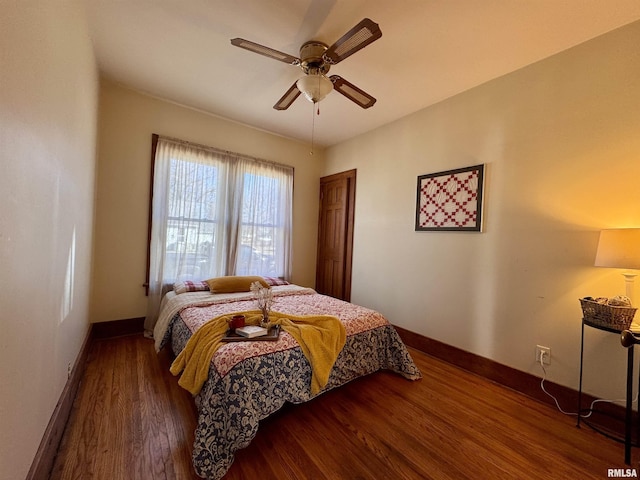 bedroom featuring ceiling fan, baseboards, and wood finished floors