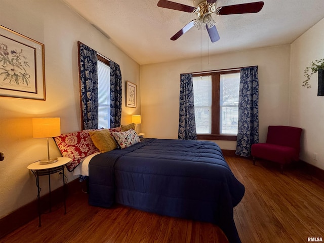 bedroom with a ceiling fan, multiple windows, wood finished floors, and a textured ceiling