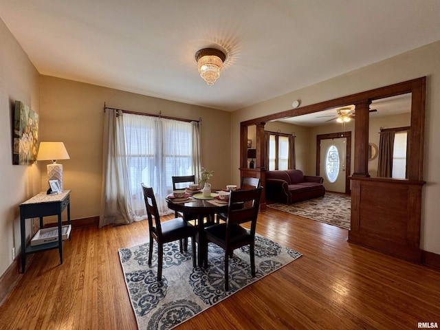 dining area featuring baseboards, ceiling fan, and light wood finished floors