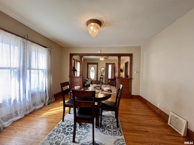 dining space featuring light wood-type flooring, visible vents, and baseboards