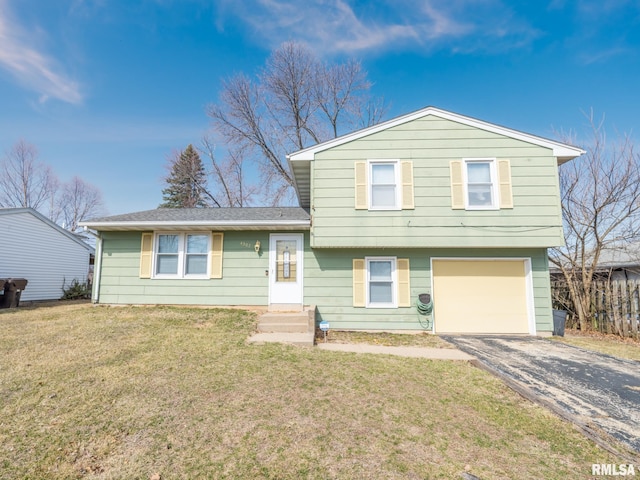 split level home featuring aphalt driveway, an attached garage, and a front lawn