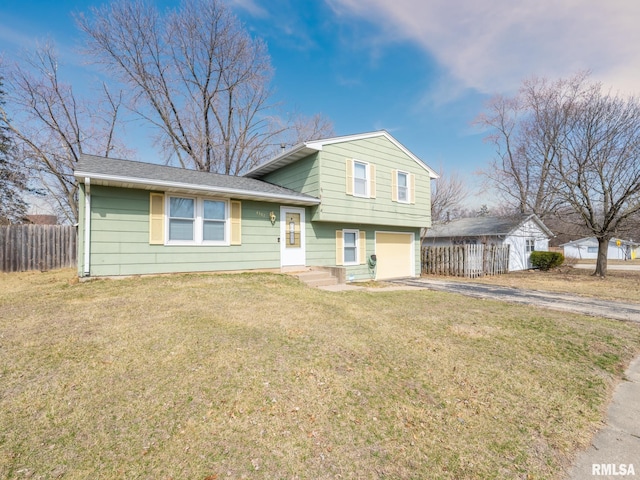 tri-level home with an attached garage, a shingled roof, a front lawn, fence, and driveway