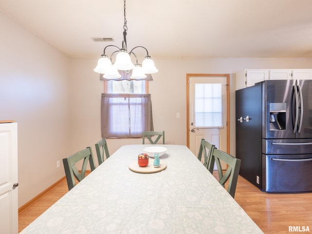 dining room with a chandelier, visible vents, baseboards, and light wood-style floors