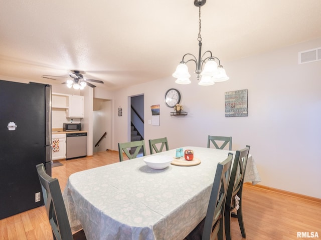 dining area featuring stairs, ceiling fan with notable chandelier, visible vents, and light wood-type flooring