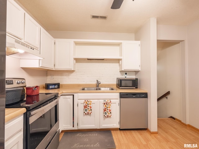 kitchen with visible vents, a sink, light countertops, appliances with stainless steel finishes, and white cabinetry