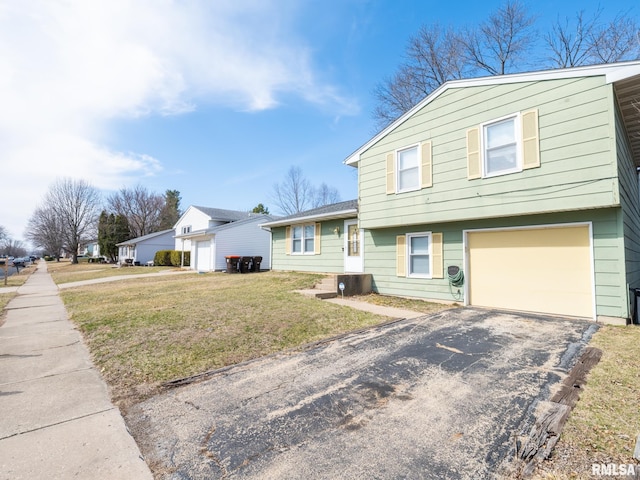 view of front of house featuring a front lawn, a garage, and driveway