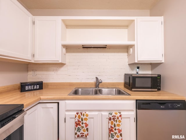 kitchen with dishwasher, white cabinets, and a sink