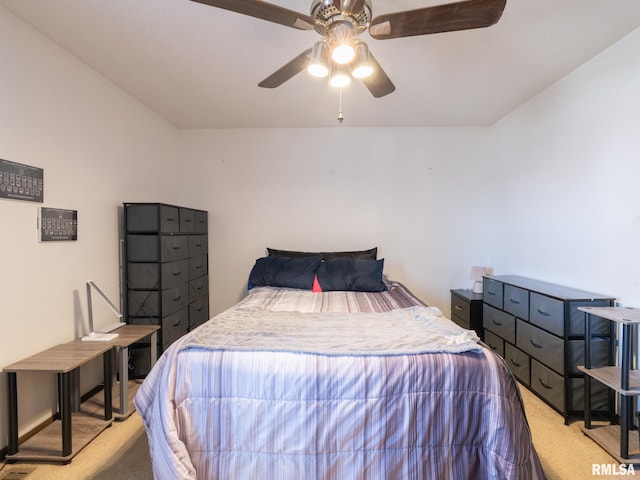 bedroom featuring light colored carpet, baseboards, and a ceiling fan