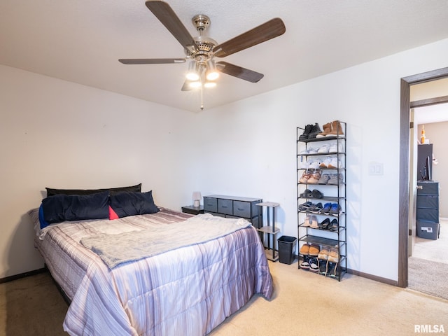 bedroom featuring baseboards, light carpet, and ceiling fan