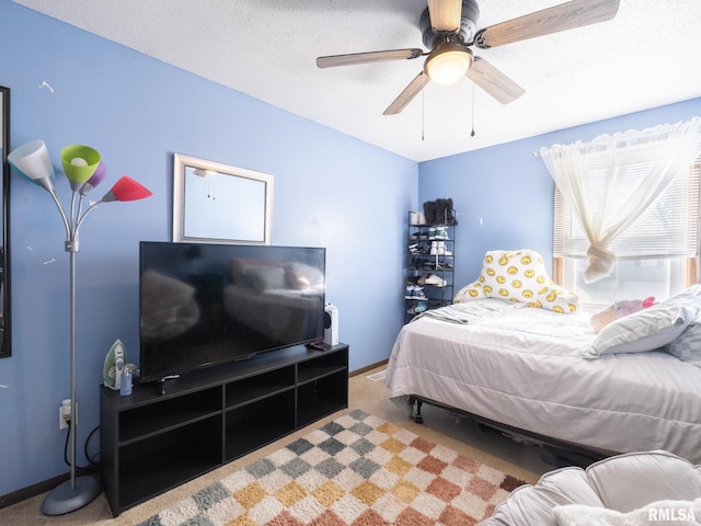 carpeted bedroom with a ceiling fan, baseboards, and a textured ceiling