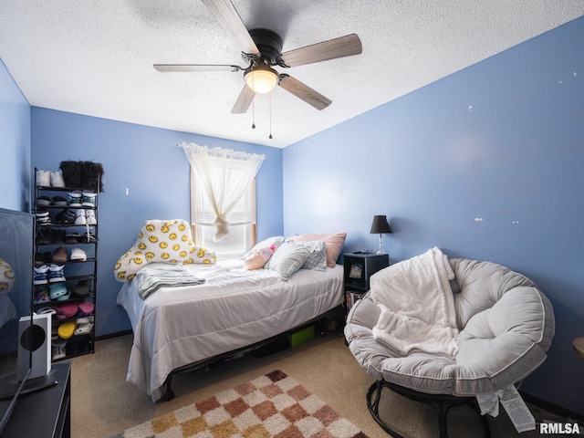 carpeted bedroom featuring a textured ceiling and a ceiling fan