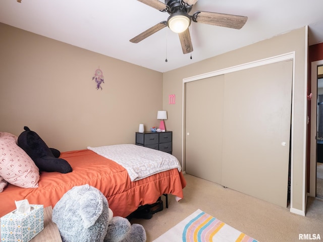 carpeted bedroom with a ceiling fan and a closet