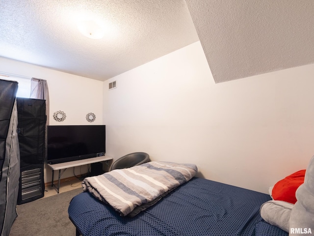 bedroom featuring visible vents, a textured ceiling, and carpet floors